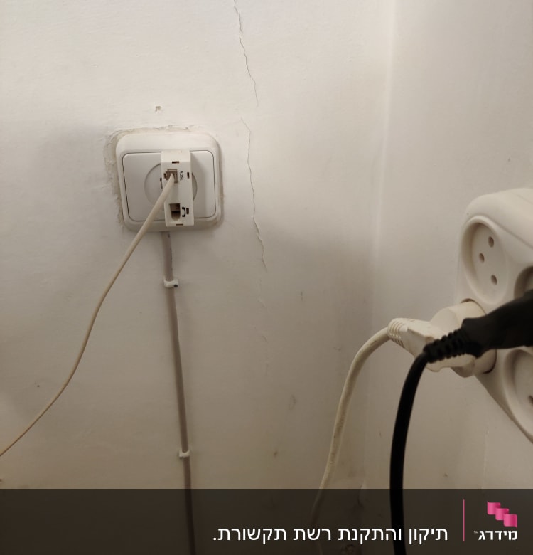 שקע רשת עם כבל מחובר לקיר לבן